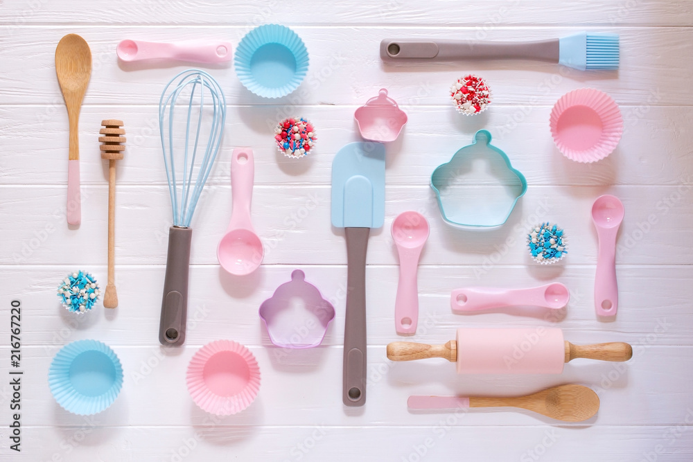 Baking and cooking concept. Pattern made of cookie cutters, whisk, roller pin and kitchen bake tools for making sweets. White background. Top view of a holiday baking still life Baking and cooking concept. Pattern made of cookie cutters, whisk, roller pin and kitchen bake tools for making sweets. White background. Top view of a holiday baking still life