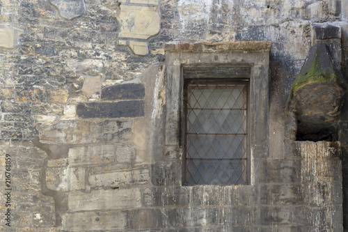 The rusty window in the old brick wall