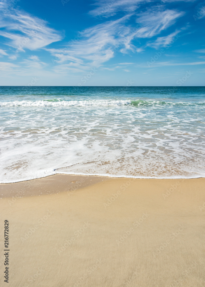 Waves breaking on beach with blue sky - Port Elizabeth, South Africa