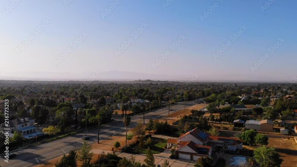 AERIAL drone rising above city streets with cars and clear skies. AERIAL drone rising above city streets with cars and clear skies.