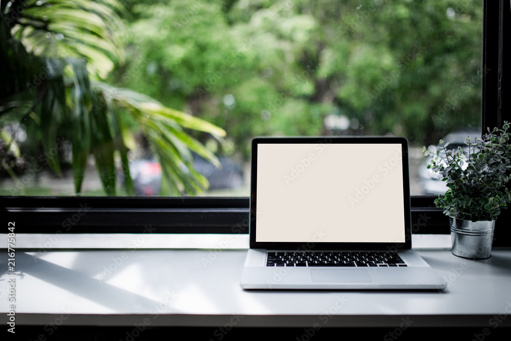 Laptop on white table in a cafe shop Laptop on white table in a cafe shop