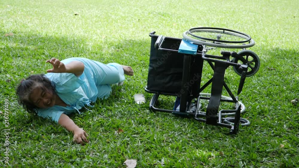 Elderly woman patient want to help after wheelchair overturned in the ground Elderly woman patient want to help after wheelchair overturned in the ground