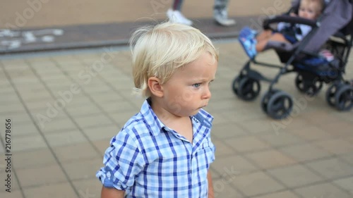 surprised cute 18 monts old baby boy in crowd panoramic shot photo