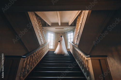 bride and groom on steps of a spiral staircase