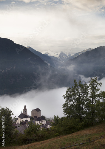 Fotografiet church in valley of wallis with mountains in the background