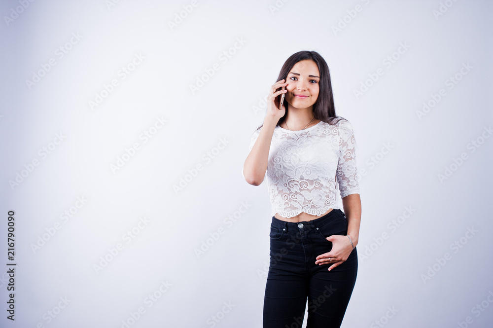 Portrait of a young beautiful woman in white top and black pants using her phone. Portrait of a young beautiful woman in white top and black pants using her phone.