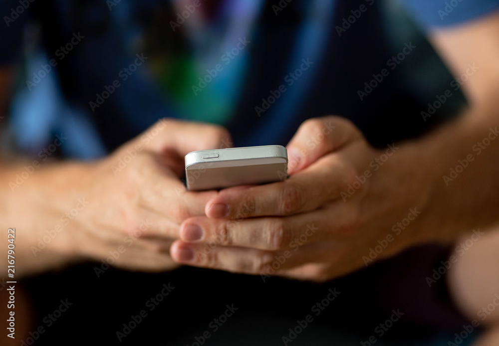 close-up of man hands holding a smart cell mobile phone in a over use of technology concept. close-up of man hands holding a smart cell mobile phone in a over use of technology concept.