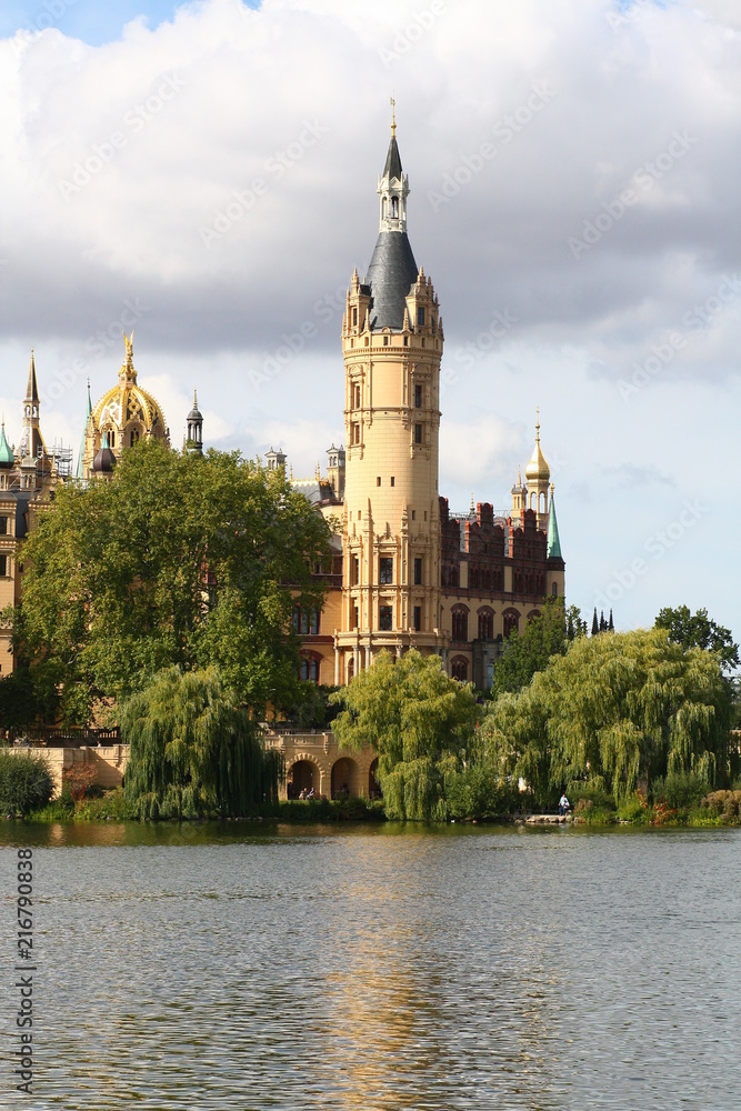 Schweriner Schloss spiegelt sich im Wasser im Sonnenuntergang