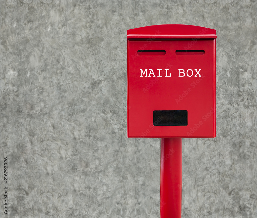 Red mail box with cement wall as background Red mail box with cement wall as background