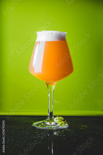 NEIPA Hop Bomb Beer over Green Background photo