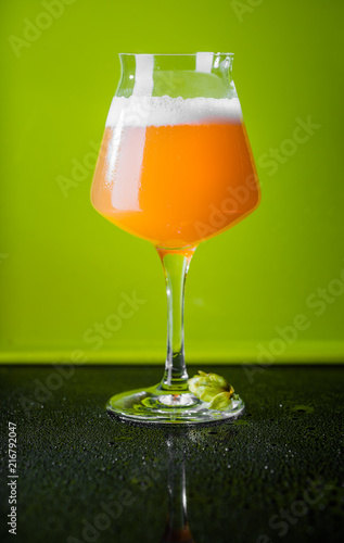 NEIPA Hop Bomb Beer over Green Background photo