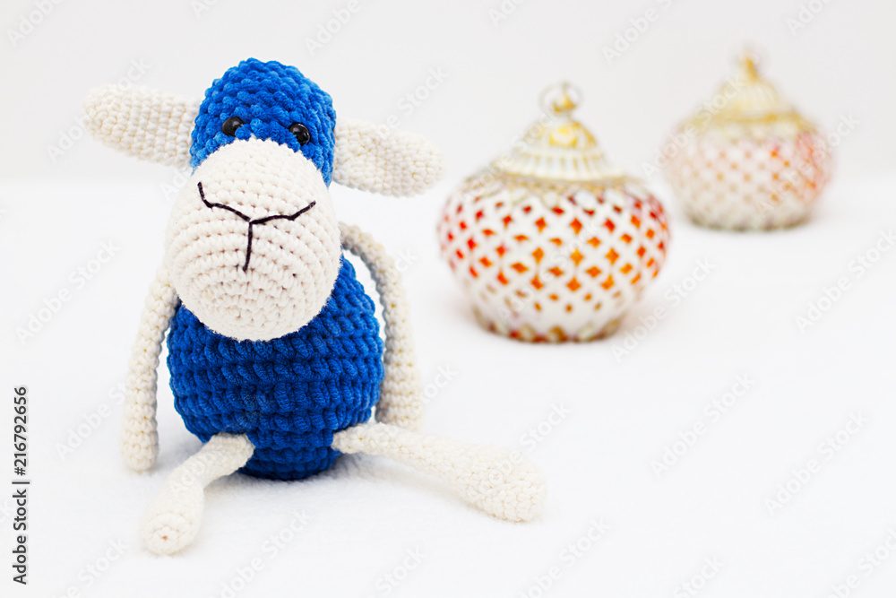 Fototapeta premium Greeting card on white background. Eid Al Adha sacrifice festival, Islamic Arabic candle and blue sheep
