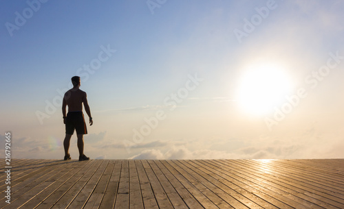 A man standing on a wooden platform at sunset high in the mountains of Sochi, Russia, 08/22/2017   © smilewalli
