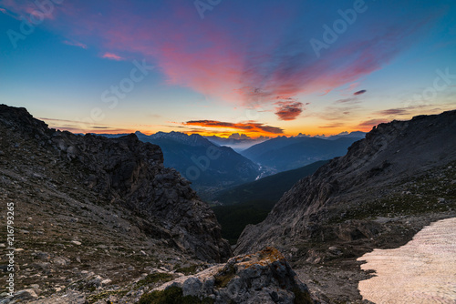 The Alps at sunrise. Colorful sky majestic peaks, dramatic valleys, rocky mountains. Expansive view from above.