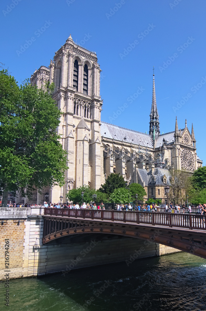 Paris, France-MAY 06, 2018: Notre Dame Cathedral or Notre-Dame de Paris-Catholic church in the center of Paris, one of the symbols of the Paris. Petit Pont - Cardinal Lustiger at the foreground