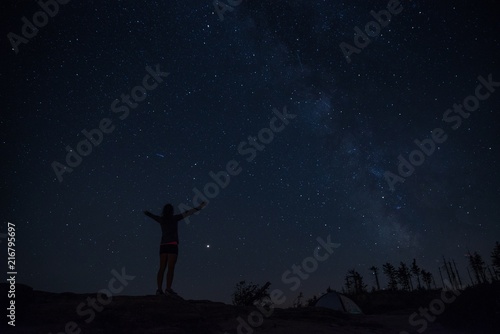 Young woman enjoying starry night on mountain trail