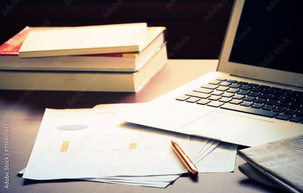 Working table which have chart paper and pen and newspaper and notebook and stack of books. Working table which have chart paper and pen and newspaper and notebook and stack of books.