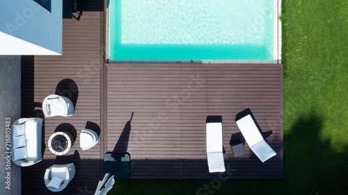 Detail of the swimming pool with deckchairs and lawn from above. Nobody inside
