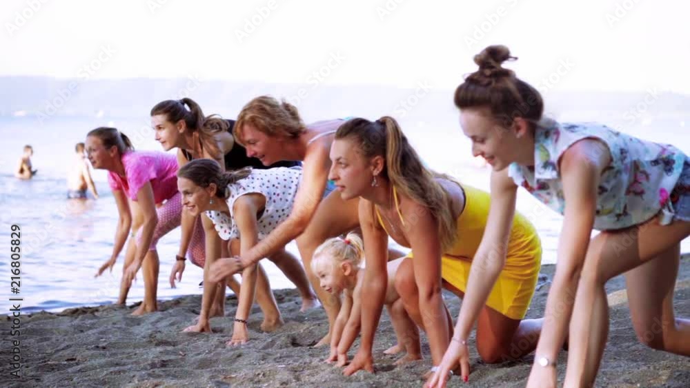 Friends having fun running down the beach during summer vacation. Group of young people together at beach. Slow motion 100fps Friends having fun running down the beach during summer vacation. Group of young people together at beach. Slow motion 100fps