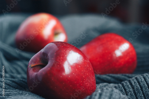 Red apples on gray woolen background
