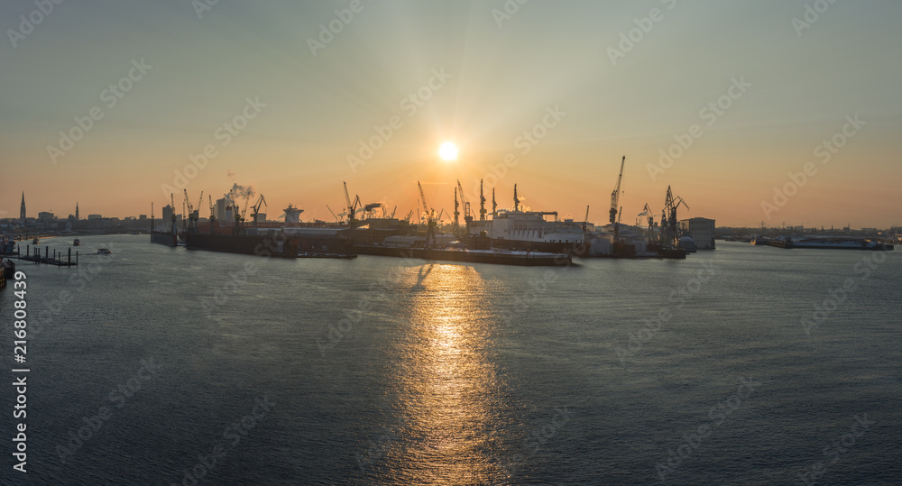 Der Hamburger Hafen bei Sonnenaufgang mit Elbphilharmonie im Hintergrund