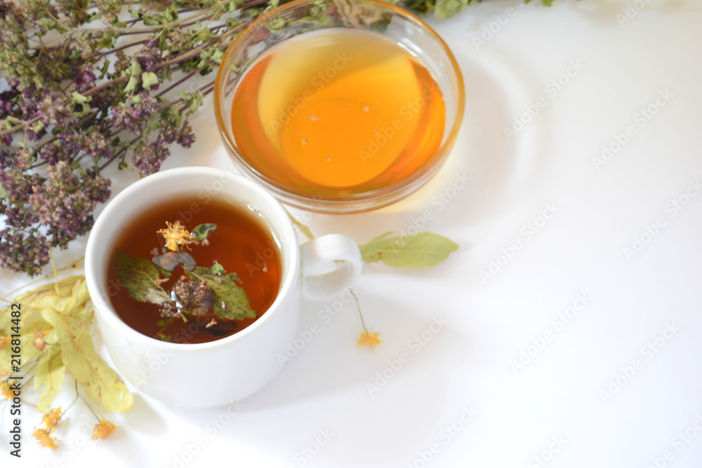 Cup of herbal tea, honey, herbs on a light background. Copy space