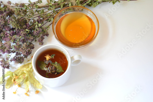 Cup of herbal tea, honey, herbs on a light background. Copy space