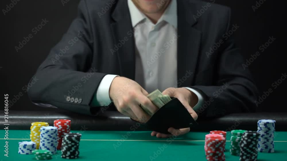 Happy male putting dollar bills in wallet, jackpot prize, game fortune, gambling Happy male putting dollar bills in wallet, jackpot prize, game fortune, gambling