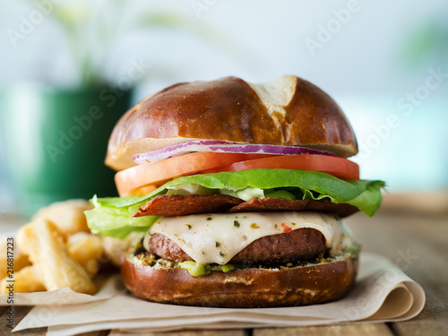 vegan cheese burger on pretzal bun and meatless bacon photo