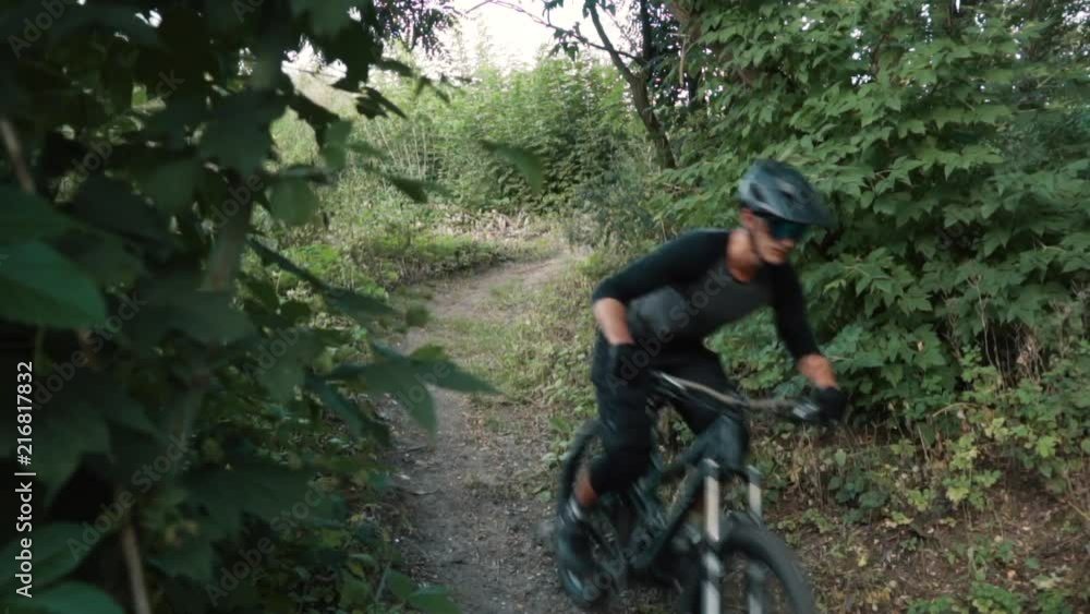 mountain biker rushes along road in forest mountain biker rushes along road in forest
