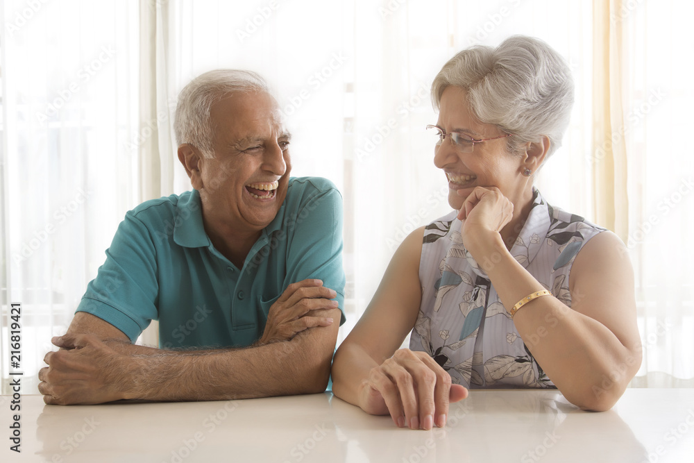 Senior couple talking sitting at table Senior couple talking sitting at table