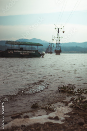 Industrial rope trolley, railway next to a abandoned boat at coast © Aneszej