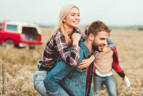 attractive young woman piggybacking on boyfriends back photo