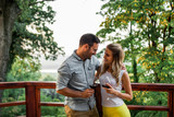 Cute couple on a vacation. Standing on a balcony with a view on beautiful nature.