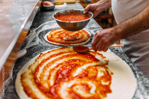 Fotografia Chef baker making pizza at the kitchen