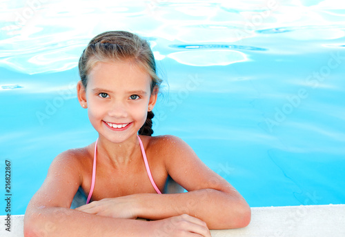 Cute smiling happy little girl child in swimming pool