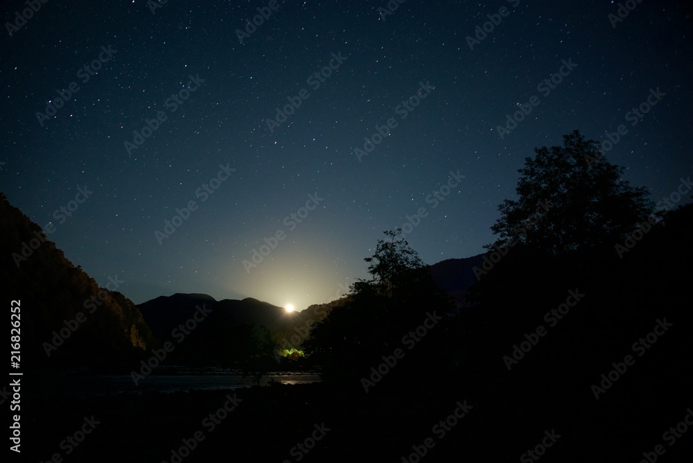The moon over mountains at night. Wide valley of the river. The moon over mountains at night. Wide valley of the river.