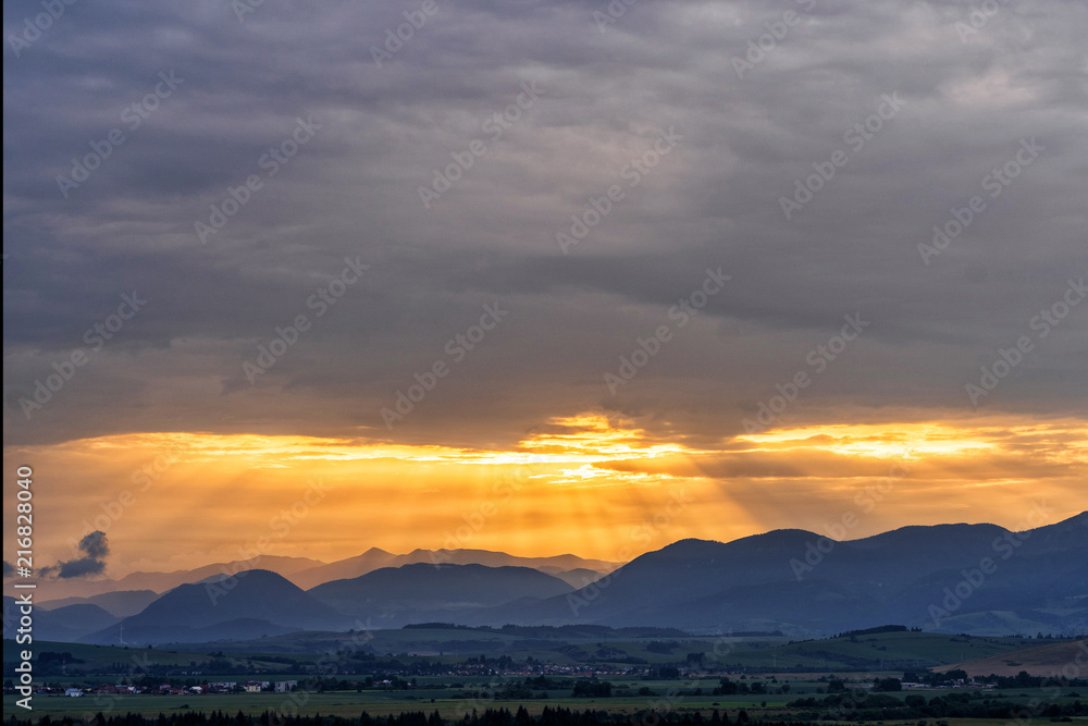 Obraz premium Mountains with last rays of setting sun during a colourful sunset.