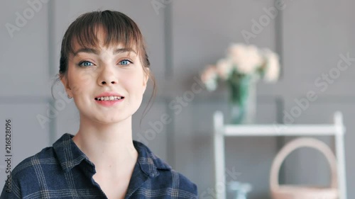 Portrait of beautiful European young woman with blue eyes at modern home interior photo