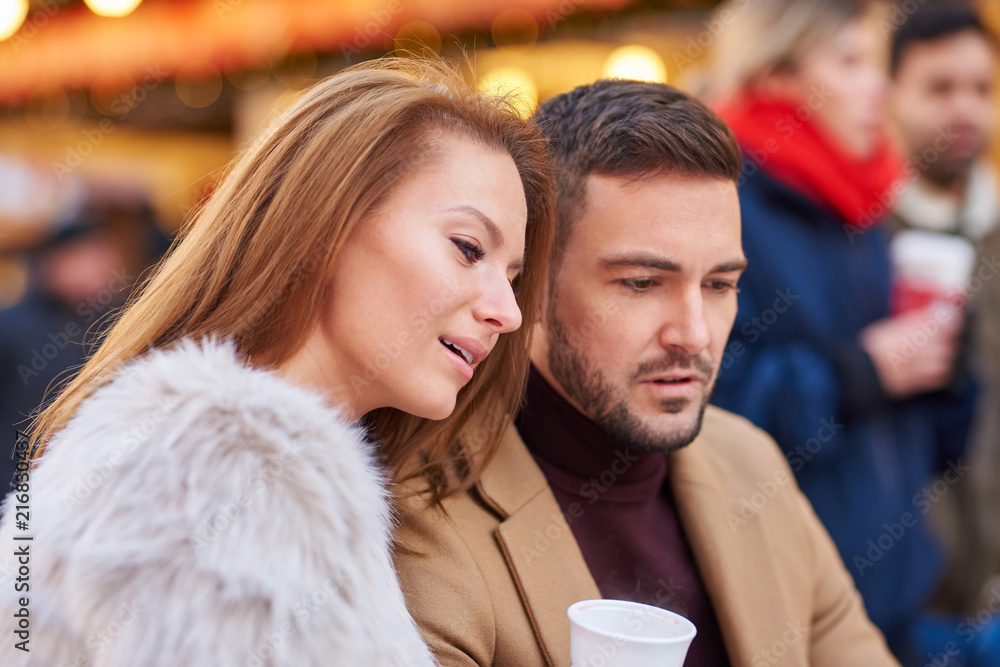 Portrait of a beautiful young couple drinking mulled wine in a christmas market. Portrait of a beautiful young couple drinking mulled wine in a christmas market.