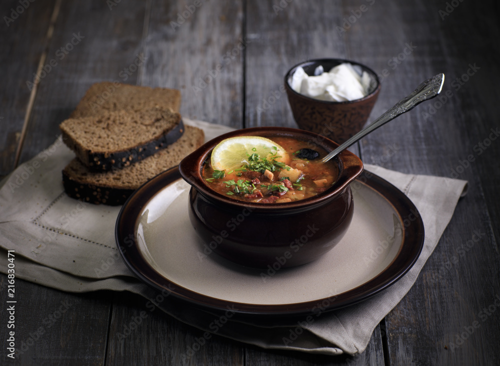 russian soup on the wooden table. Solyanka rustic style russian soup on the wooden table. Solyanka rustic style