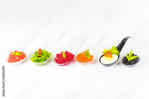Fototapeta Naklejka Na Ścianę i Meble -  Plastic spoons with fish caviar on a white background. 