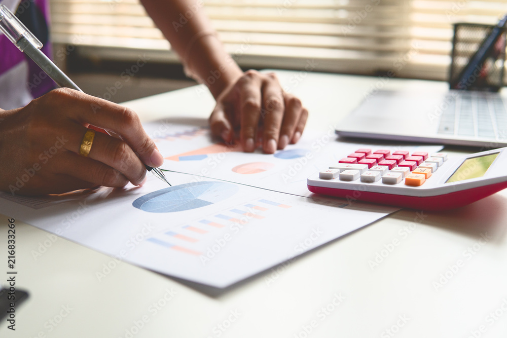 Businessman or Finance managers check about cost and doing finance graph report at office, Businessman recheck new plan financial graph data. Businessman or Finance managers check about cost and doing finance graph report at office, Businessman recheck new plan financial graph data.