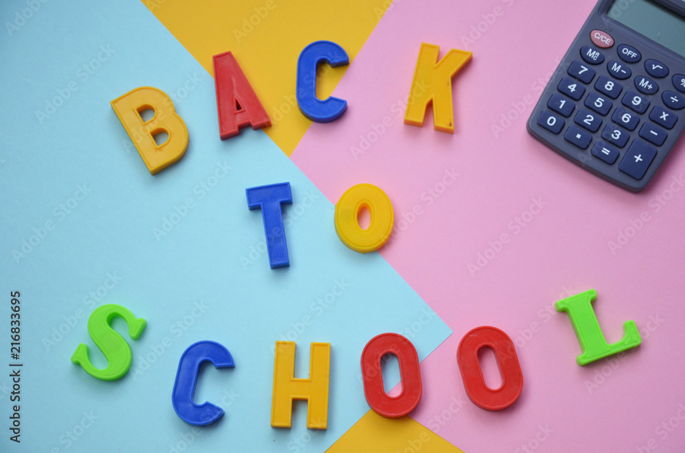 Naklejka premium School office supplies with copy space. Back to school text concept. inscription flattering back to school on a colorful bright abstract Top view.