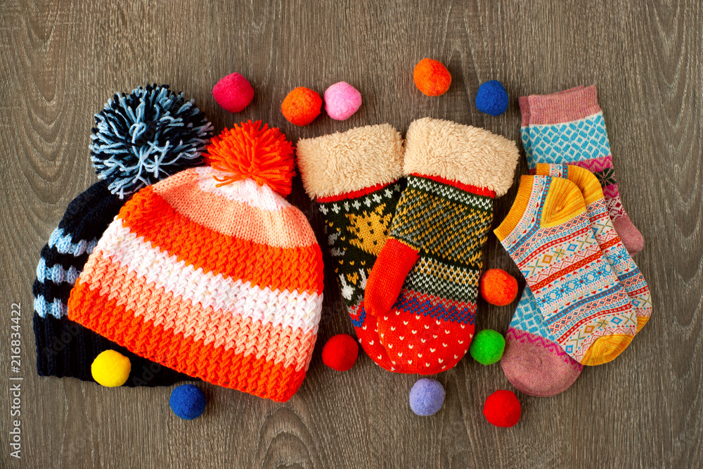 Caps, mittens and socks for cold seasons. Warm clothes in the form of  knitted hats, colorful mittens and socks on a wooden background. Clothes  for autumn and winter. Stock Photo | Adobe