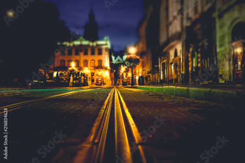 Illuminated street of old european town at night. Tilt-shift effect
