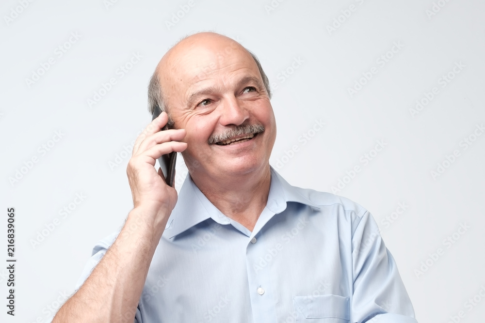 Portrait of happy european senior man talking on phone and smiling Portrait of happy european senior man talking on phone and smiling