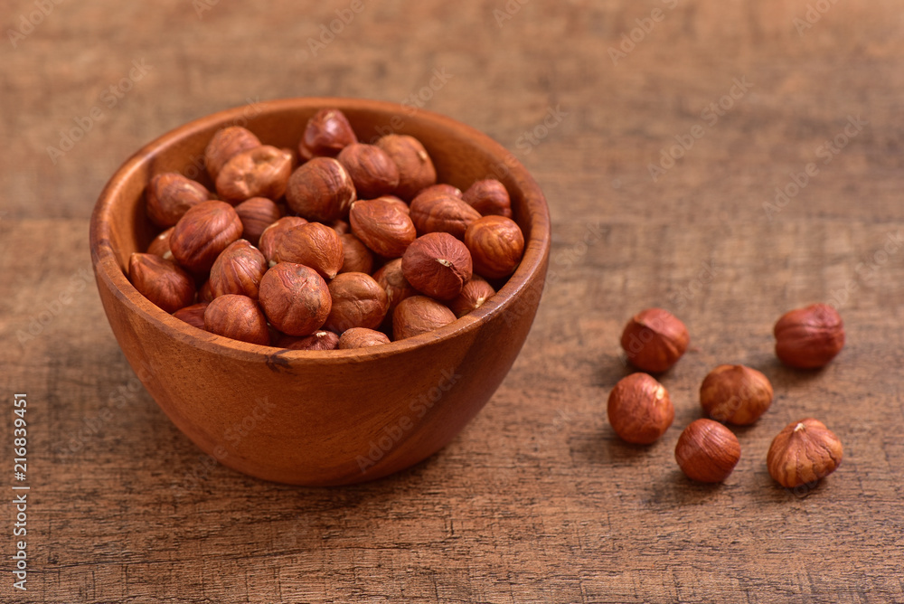 Fototapeta premium Hazelnuts bowl on wooden background