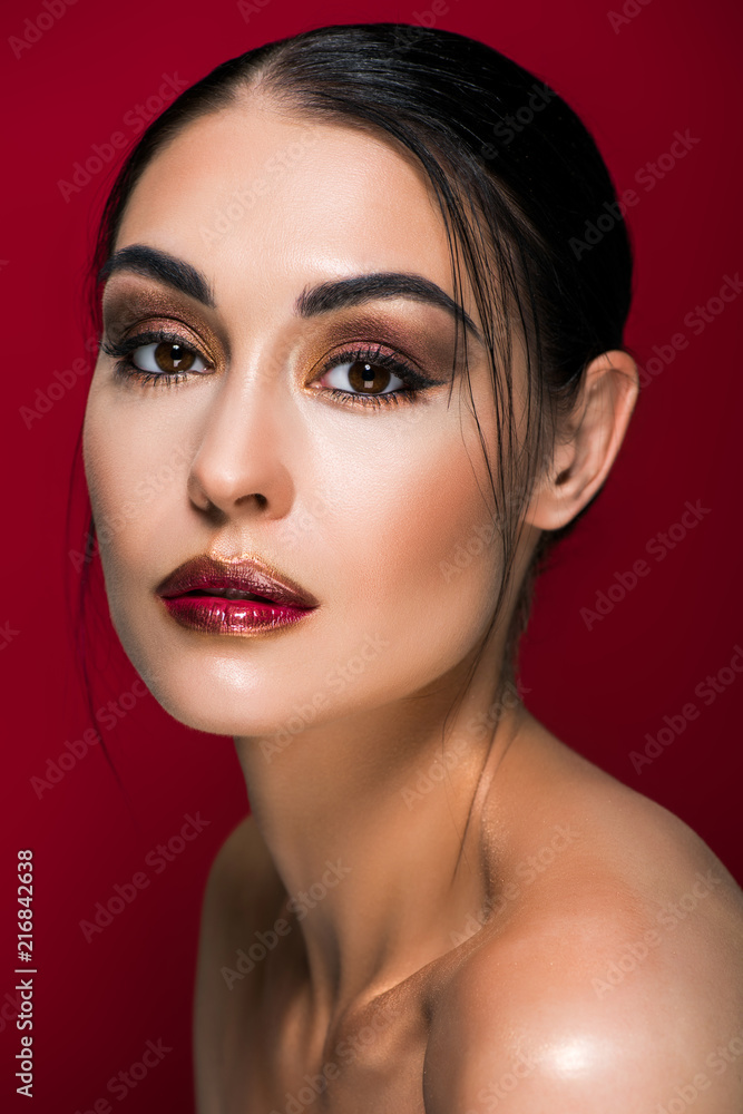 Fototapeta premium portrait of beautiful nude girl with makeup, isolated on red