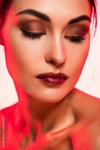 portrait of beautiful girl with closed eyes and makeup   red toned picture